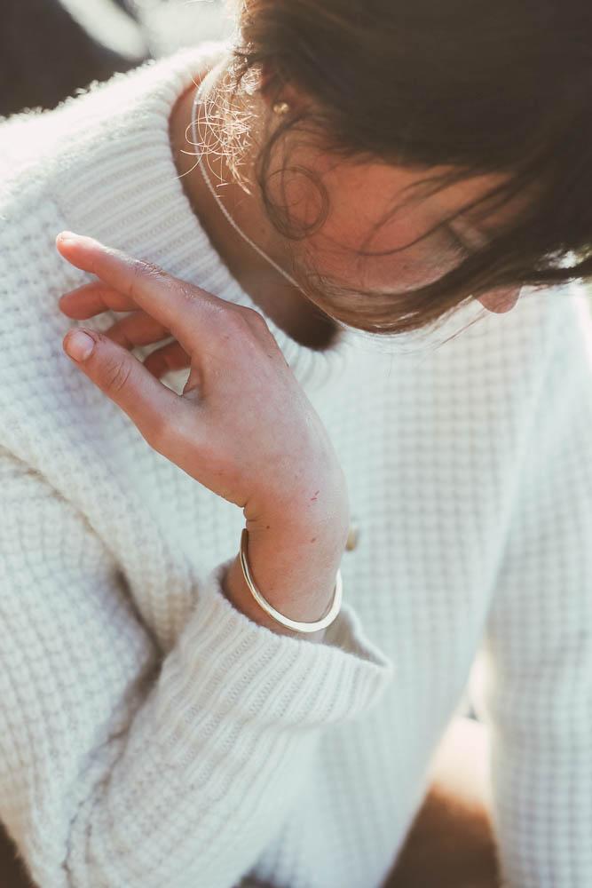 brass bracelet worn by model in artful pose